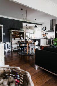 Moderne landelijke keuken met houten vloer, eettafel en vintage kast.