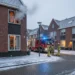 Brandweer blust woningbrand in Nederlandse woonwijk tijdens winteravond