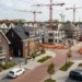 Nieuwbouw woningen in Nederland met huizen in aanbouw en bouwkranen in woonwijk