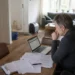 Waterschade in een woonkamer met verzekeringspapieren en laptop op tafel